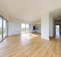 3i. BYT SO ZÁHRADOU +TEP. ČERPADLO, KLIMATIZÁCIA A ŽALÚZIE V CENE - Priestranný obývací priestor v 3-izbovom byte s drevenou podlahou a veľkými oknami.