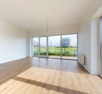 3i. BYT SO ZÁHRADOU +TEP. ČERPADLO, KLIMATIZÁCIA A ŽALÚZIE V CENE - Priestranná obývačka s veľkými oknami a výhľadom v 3-izbovom byte.