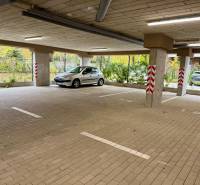 NA PRENÁJOM GARÁŽOVÉ STÁTIE, SADOVÁ UL. SENICA - Priestranné parkovanie v garážach na Sadovej ulici v Senici s autom a stĺpmi.