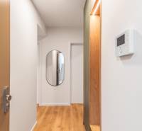 PRENÁJOM 3 izbový byt s predzáhradkou, BORY PROMENÁDA - Na chodbe 3-izbového bytu je zrkadlo a podlaha s dreveným dekorom.