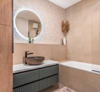 PRENÁJOM 3 izbový byt s predzáhradkou, BORY PROMENÁDA - Kúpeľňa v 3-izbovom byte so vzorovanou stenou, okrúhlym zrkadlom a vaňou.