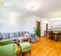 Na predaj: Rodinný dom Slatinské Lazy s očarujúcou atmosférou - Obývacia izba rodinného domu s podlahou s dreveným dekorom, veľkou sedacou súpravou a kuchynským pultom.