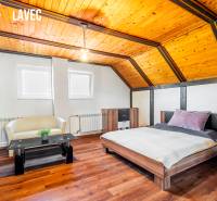 Na predaj: Rodinný dom Slatinské Lazy s očarujúcou atmosférou - Podkrovná izba v rodinnom dome s podlahou z dreveným dekorom a dreveným stropom.