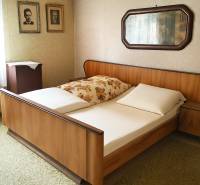 HD reality ponúka, predaj, rodinný dom Rykynčice  - Spálňa s drevenou posteľou, fotografiami na stene a zrkadlom v rodinnom dome.