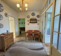 Novinka: Priestranný svetlý byt s balkónmi pri Kuchajde. Vajnorská - Jedáleň v 3-izbovom byte s dreveným dekorom, koberec, stôl a dekoratívne taniere.