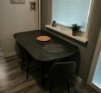 Prenajmeme 3 izb  byt na Korytnickej ulici - Jedálenský kút v 3-izbovom byte s podlahou s dreveným dekorom, s jednoduchým zariadením.