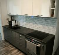 Prenajmeme 3 izb  byt na Korytnickej ulici - Kuchyňa v 3-izbovom byte s tmavými skrinkami a podlahou s dreveným dekorom.