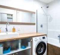 Na prenájom štýlový  3 - izb. byt  (Košice - Sever) - Kúpeľňa s umývadlom, práčkou a vaňou v 3-izbovom byte, podlaha s dreveným dekorom.