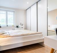 Na prenájom štýlový  3 - izb. byt  (Košice - Sever) - Spálňa v 3-izbovom byte s podlahou s dreveným dekorom a bielym nábytkom.