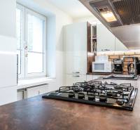 Na prenájom štýlový  3 - izb. byt  (Košice - Sever) - Kuchyňa v 3-izbovom byte s bielymi skrinkami a kuchynskou linkou s tehlovým obkladom.