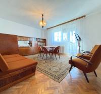 Na predaj: Rodinný dom v meste Levice - Obývačka rodinného domu s retro nábytkom a podlahou s dreveným dekorom.