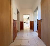 Na predaj: Rodinný dom v meste Levice - Chodba rodinného domu s keramickou dlažbou a paleťovanou drevenou stenou.