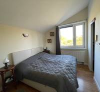 PREDAJ krásny 6 izb. rod. dom prepojený s prírodou - Spálňa v rodinnom dome s posteľou a podlahou s dreveným dekorom.