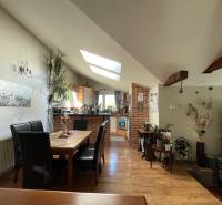 PREDAJ krásny 6 izb. rod. dom prepojený s prírodou - Jedáleň s podlahou s dreveným dekorom, stolom a čiernymi stoličkami v rodinnom dome.