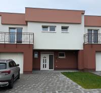 HD REALITY, Predaj 4-izbový rodinný dom v Šuranoch - Na Vršku - Rodinný dom v Šuranoch s garážou a balkónmi, zaparkované auto, zatrávnená plocha.