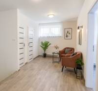 HD REALITY, Predaj 4-izbový rodinný dom v Šuranoch - Na Vršku - Interiér rodinného domu s podlahou s dreveným dekorom, pohodlnými kreslami a rastlinami.