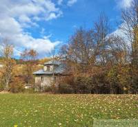 Dom v pôvodnom stave na krásnom pozemku (2130m2) v malej dedinke na Li - Rodinný dom v Liptovských Beharovciach obklopený jesennými stromami a zelenou lúkou.