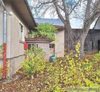 Dom v pôvodnom stave na krásnom pozemku (2130m2) v malej dedinke na Li - Na dvore rodinného domu v Liptovských Beharovciach vidieť stromy a drevené stavby.