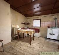 Malá chalúpka pod hrádzou – Zemné - Kuchyňa v rodinnom dome s podlahou s dreveným dekorom a jednoduchým vybavením.