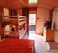 Chata nad kúpeľmi Dudince s vlastným pozemkom - Interiér chaty so štyrmi posteľami a presvetleným výhľadom na terasu.