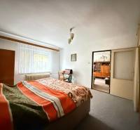 Rodinný dom s veľkým pozemkom v obci Sklené,  - Spálňa v rodinnom dome so svetlým kobercom, oknom a posteľou s dekou.