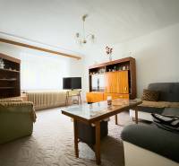 Rodinný dom s veľkým pozemkom v obci Sklené,  - Obývačka v rodinnom dome s pohovkami, skrinkami a stolíkom, kobercom na podlahe.