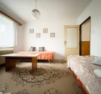 Rodinný dom s veľkým pozemkom v obci Sklené,  - Obývacia izba v rodinnom dome s dvoma pohovkami a stolom na koberci.