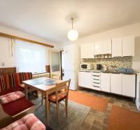 Rodinný dom s veľkým pozemkom v obci Sklené,  - Kuchyňa v rodinnom dome so svetlým nábytkom, jedálenským stolom a posedením.