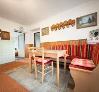 Rodinný dom s veľkým pozemkom v obci Sklené,  - Jedáleň rodinného domu s rohovou lavicou, dreveným dekorom a dekoratívnymi obrázkami na stene.