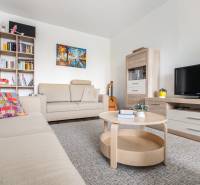 REWIN I Priestranný 3 izbový byt v tichej lokalite Senca - Obývačka s béžovým nábytkom v 3-izbovom byte, poličky, gauč a televízor.