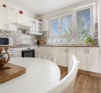 REWIN I Priestranný 3 izbový byt v tichej lokalite Senca - Kuchyňa v 3-izbovom byte s bielym nábytkom, jedálenský stôl a veľké okná.