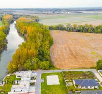 NA PREDAJ INVESTIČNÝ STAVEBNÝ POZEMOK, JAHODNÁ - Developerské pozemky v Jahodnej pri rieke, obklopené širými poľami a novými budovami.