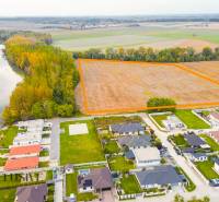 NA PREDAJ INVESTIČNÝ STAVEBNÝ POZEMOK, JAHODNÁ - Krajina v Jahodnej s developerskými pozemkami pri rieke a blízkymi domami.