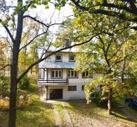 Rekreačná chata Šaštín-Stráže Gazárka komerčné využitie - Chata na ulici Gazárka, Šaštín-Stráže, obklopená stromami a zaparkovaným autom.