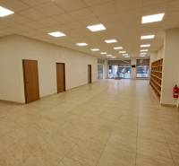 PRENÁJOM: Obchodný priestor 158m2 - Mostová ulica, Ružomberok - Obchodné priestory s dlažbou, regálmi a presklenými dverami pre vstup.