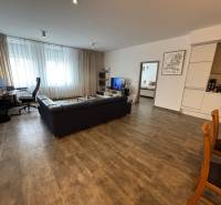 Veľký 96 m2  2 izbový byt s garážovým státím Topoľčany Centrum  - Obývacia miestnosť 2-izbového bytu s tmavým gaučom a pracovným kútom.