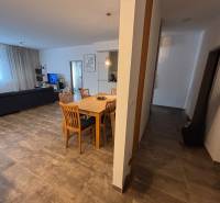 Veľký 96 m2  2 izbový byt s garážovým státím Topoľčany Centrum  - Jedálenský stôl s drevenými stoličkami v 2-izbovom byte. Súčasťou je pohovka a televízor.