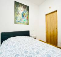 NA PRENÁJOM ŠTÝLOVÝ 2-IZBOVÝ BYT V CENTRE KOŠÍC, DREVNÝ TRH - Spálňa s obrazom na stene, posteľou a nočným stolíkom v 2-izbovom byte.