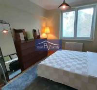 PRENAJATÉ - PRENÁJOM, KOŠICKÁ, RUŽINOV - 2 IZBOVÝ BYT - Spálňa v 2-izbovom byte s veľkým zrkadlom a podlahou s dreveným dekorom.