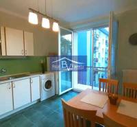 PRENAJATÉ - PRENÁJOM, KOŠICKÁ, RUŽINOV - 2 IZBOVÝ BYT - Kuchyňa v 2-izbovom byte s bielymi skrinkami, jedálenským stolom a balkónom.