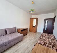 REZERVOVANÝ 2,5 IZBOVÝ BYT, 65 M2,PREŠOV,UL. FEDERÁTOV - Obývacia izba v 3-izbovom byte s podlahou s dreveným dekorom a jednoduchým nábytkom.