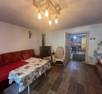 !! NOVÁ CENA !! predaj romantickej chalúpky v Šípkove  - Pohodlná izba v chate s útulným sedením, krbom a dreveným stropom.