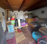 !! NOVÁ CENA !! predaj romantickej chalúpky v Šípkove  - Interiér nepoužívanej chaty s vidieckym nábytkom a stropnými trámami.