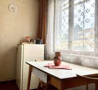 3-izbový byt s loggiou v širšom centre, Komárno - Jedáleň v 3-izbovom byte so stolom, stoličkami a záclonami s kvetinovým vzorom.