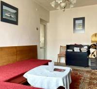 3-izbový byt s loggiou v širšom centre, Komárno - Obývacia izba v 3-izbovom byte s pohovkou, kobercom a dekoračnými obrázkami na stene.