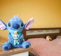 4i mezonet, 133m2, vlastné kúrenie, Melčice-Lieskové - Izba v 4-izbovom byte so žltými stenami, hračkami a posteľou s ružovým prehozom.