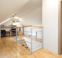 4i mezonet, 133m2, vlastné kúrenie, Melčice-Lieskové - Podkrovná pracovňa v 4-izbovom byte s dreveným dekorom podlahy a zábradlím.