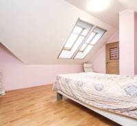 4i mezonet, 133m2, vlastné kúrenie, Melčice-Lieskové - Svetlá spálňa s dvojsikmými strešnými oknami a podlahou s dreveným dekorom v 4-izbovom byte.