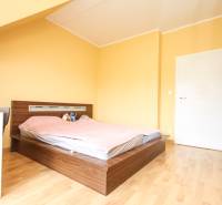 4i mezonet, 133m2, vlastné kúrenie, Melčice-Lieskové - Spálňa v 4-izbovom byte s posteľou a podlahou s dreveným dekorom.