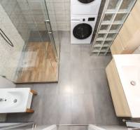 4i mezonet, 133m2, vlastné kúrenie, Melčice-Lieskové - Kúpeľňa s práčkou a sprchovým kútom v 4-izbovom byte, podlaha s dreveným dekorom.